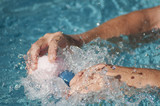 Fototapeta  - closeup of hands of man splashing with plastic rubber ducks toys in swimming pool