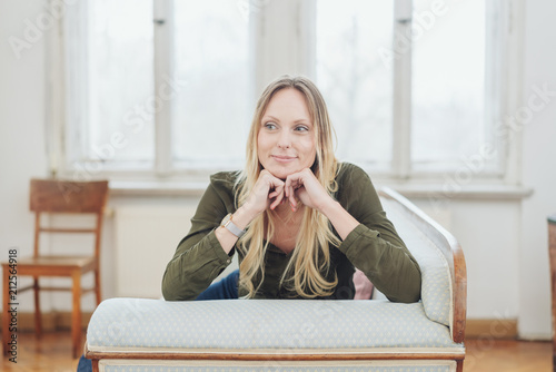 Fotografie, Obraz Thoughtful young woman sitting on a couch