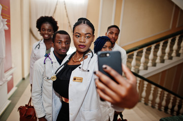 Wall Mural - Group of african doctors students inside medical university making selfie at phone.