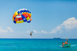 Couple of tourists flying on a colorful parachute