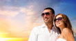© Syda Productions - love, summer and relationships concept - happy smiling couple in sunglasses over evening sky background