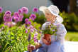 © Syda Productions - gardening and people concept - happy senior woman planting flowers at summer garden