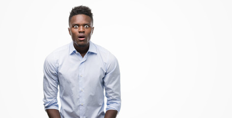 Poster - Young african american man wearing a shirt scared in shock with a surprise face, afraid and excited with fear expression