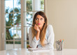 © Krakenimages.com - Beautiful young woman thinking while studying and reading at home