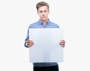 Poster - Young handsome blond man holding a banner with a confident expression on smart face thinking serious