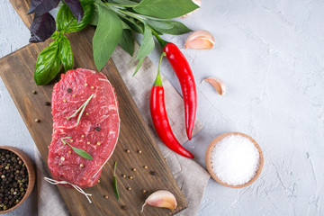 Raw beef steak with ingredients for cooking on cutting board . Top view with copy space