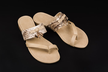 Pair of women's sandals on black background.