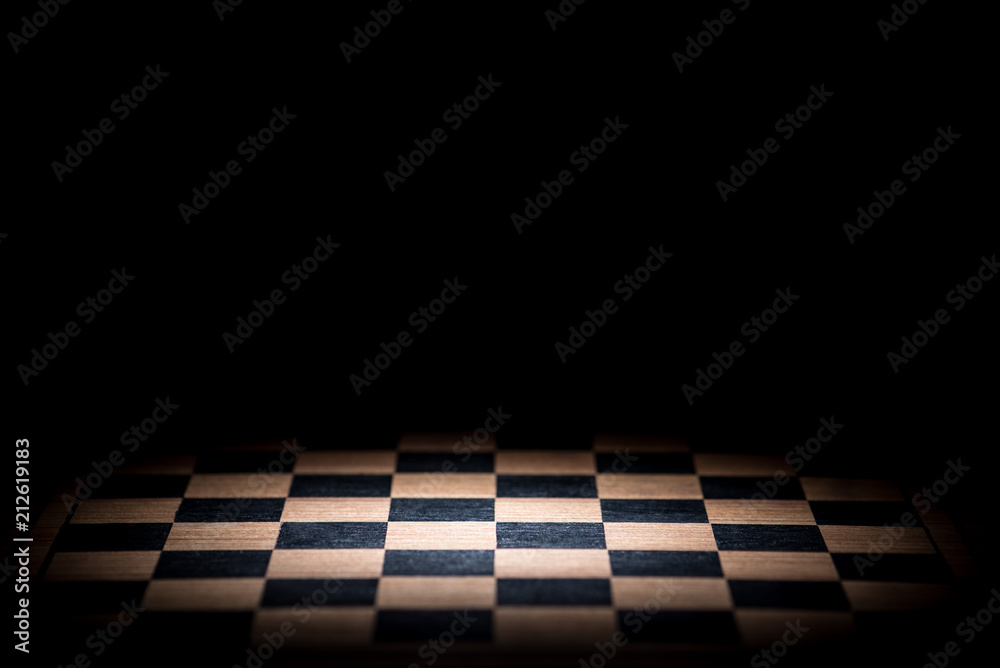 abstract chessboard on dark background lighted with snoot - obrazy, fototapety, plakaty 
