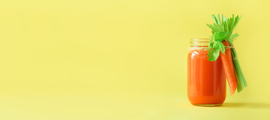 Wall Mural - Banner of carrot juice with carrots, celery on yellow background. Vegetable smothie in glass jar. Copy space. Summer food concept. Healthy detox eating, alkaline diet