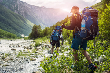 tourists with hiking backpacks on beautiful mountain landscape background. climbers hike to mounts. 