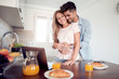 © ivanko80 - Happy young couple using laptop in the kitchen