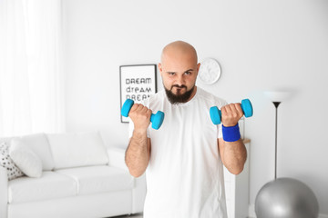 Sticker - Overweight man doing exercise with dumbbells at home