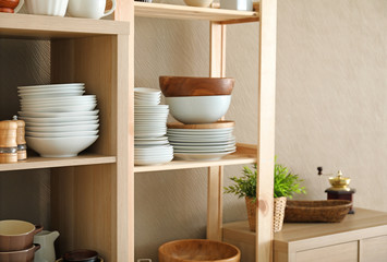 Sticker - Storage stand with ceramic and wooden kitchenware near light wall