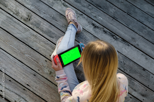 Photo  Teenager girl playing game on Nintendo Switch console