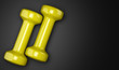 © Tiler84 - yellow dumbbells isolated on black background