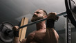 Hombre fuerte con grandes músculos levantando peso mientras entrena en el gimnasio. Ponerse en forma
