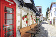 Red door with flowers with red vases on street of Alacati, Cesme, Turkey