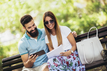 Young attractive couple talking and looking at digital tablet.