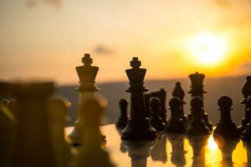 chess board game concept of business ideas and competition and strategy ideas. Chess figures on a chessboard outdoor sunset background.