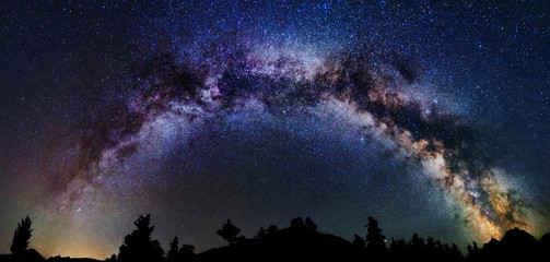Wall Mural - panoramic astrophotography of whole visible milky way galaxy. silhouette of mountains. stars, nebula