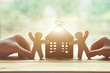 Hands holding little wooden men and house. Symbol of construction, family, sweet home concept