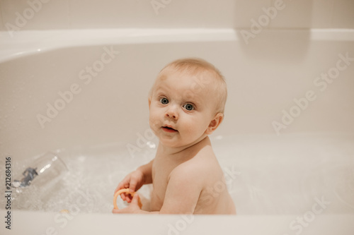 Adorable Blonde Baby Boy Playing And Smiling In The Bath Tub