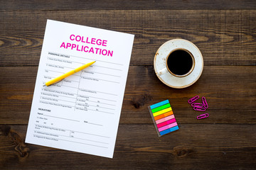 Apply college. Empty college application form near coffee cup and stationery on dark wooden background top view copy space