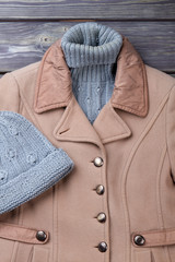 Wall Mural - Close ip brown winter coat and warm woolen sweater. Flat lay, knitted hat.