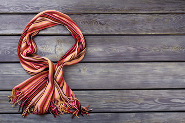 Wall Mural - Bowed colourful wool scarf. Flat lay, top view. Black background.