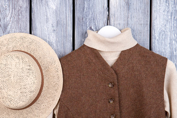 Wall Mural - Top view straw and winter clothing. Flat lay, close up. Grey desk surface background.