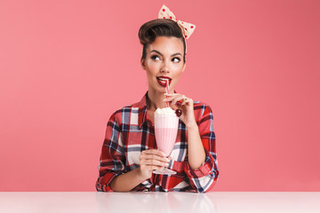 Wall Mural - Portrait of a smiling brunette pin-up girl in plaid shirt