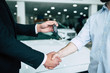 Buying a new car. Handshake and handing over the keys to the car by the salon consultant to the buyer.