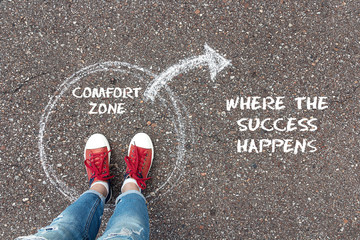 Exit from the comfort zone concept. Feet  standing inside circle comfort zone and outward arrow chalky on the asphalt.