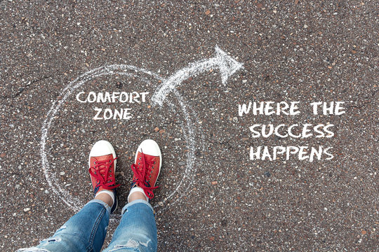exit from the comfort zone concept. feet standing inside circle comfort zone and outward arrow chalk