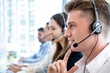 © Atstock Productions - Smiling friendly man working in call center office with team