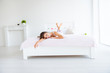 © deagreez - Full size portrait of sensual tender woman lying on stomach in bed enjoying recreation in modern white room with interior looking at camera day health healthy life
