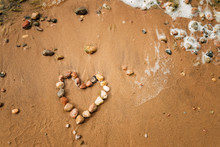 Heart Shape From Sea Stones On A Sandy Ocean Beach, Top View, Copy Space. Love Summer Vacation Background, Romance Concept