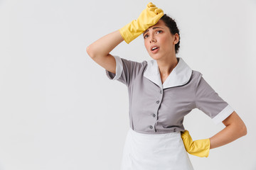 Wall Mural - Portrait of a tired young housemaid dressed in uniform