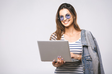 Wall Mural - Portrait of happy young beautiful smiling woman standing with laptop isolated on white background. Space for text.