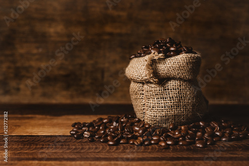 Fotografie, Obraz bunch of fresh roasted coffee beans with burlap sack on a wooden table