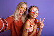 © ClaudiK - Studio lifestyle portrait of two best friends hipster girls wearing stylish bright orange outfits, dresses and sweater,sunglasses.Two beautiful young women in casual clothes in studio.