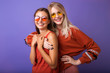 © ClaudiK - Studio lifestyle portrait of two best friends hipster girls wearing stylish bright orange outfits, dresses and sweater,sunglasses.Two beautiful young women in casual clothes in studio.
