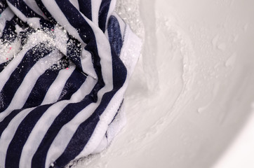 Wash a stain on white clothes under water stain powder for washing dirty bathroom