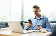 © Cressida studio - Stylish young man calling by the phone to solve business problems. Online consultation by phone. Freelancer discussing the development and planning of his online project. Outsourcing. Mobile services.
