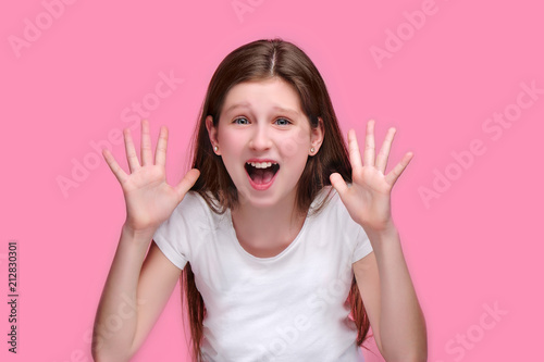 Fotomural Scared teen girl screaming of fear isolated on pink