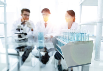 Wall Mural - background image of scientists studying blue liquid in a flask