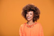 © neonshot - Portrait of afro smiling girl on yellow background.