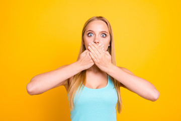 Do not tell anyone! Close up portrait of pretty cute terrified frightened girl with mute dumb silent and palms over mouth isolated yellow background. Concept of advertising