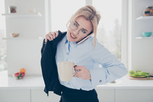 Young Attractive Adorable Smiling Blonde Woman Office Executive Worker Wearing Spectacles In Hurry Early In The Morning Talking On The Phone Putting Dark Blue Jacket On Having A Drink In Kitchen
