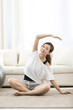 © Blue Jean Images - Young Chinese woman practicing yoga at home